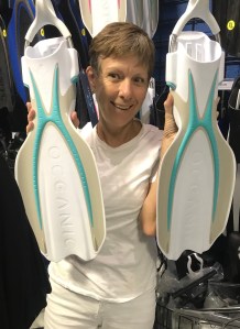 Lady holding white and green scuba fins EMPTY NEST DIVER