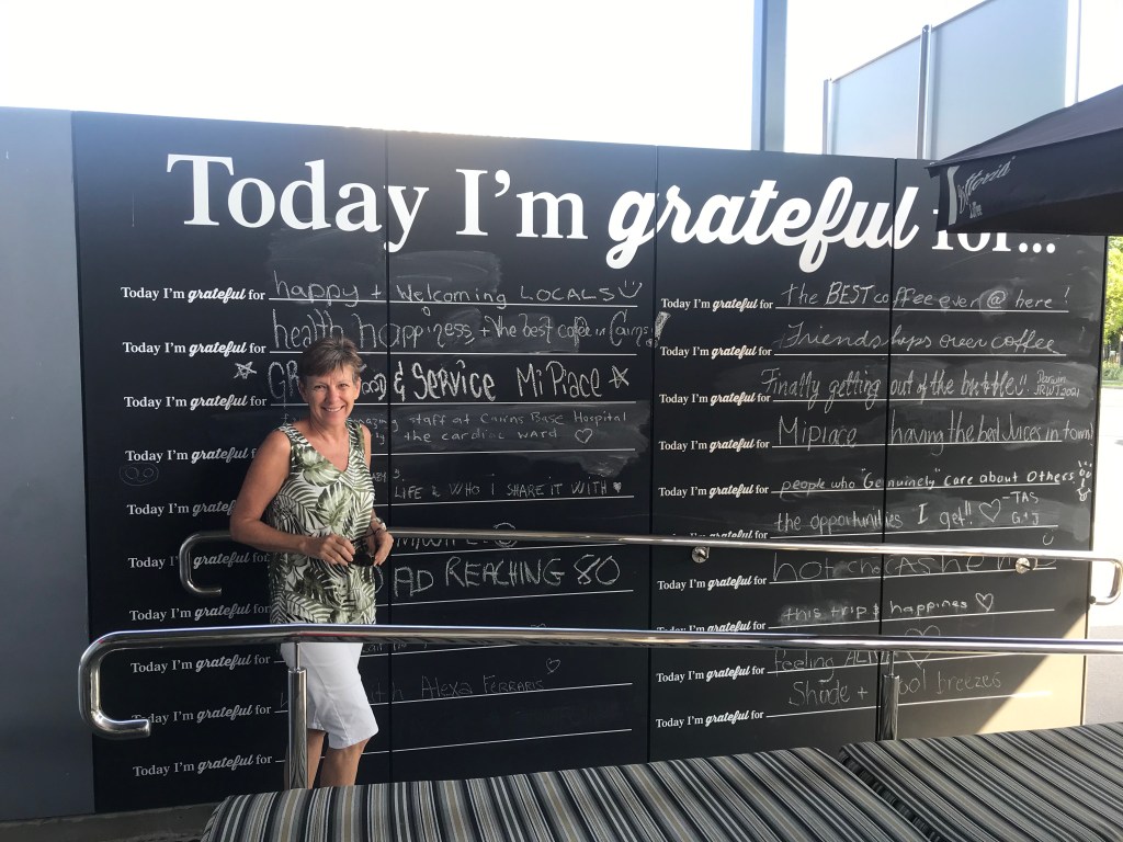 Woman in front of grateful sign EMPTY NEST DIVER