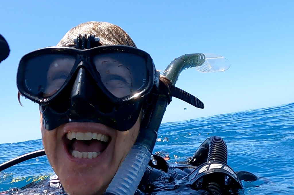 A Scuba Woman laughing while in the water