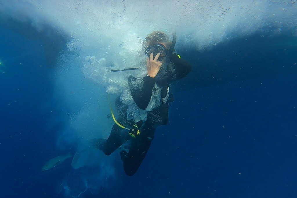 A Scuba Woman after entering the ocean surrounded by bubbles
emptynestdiver.com 