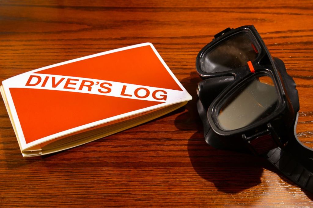 A dive log book and scuba mask
Empty Nest Diver