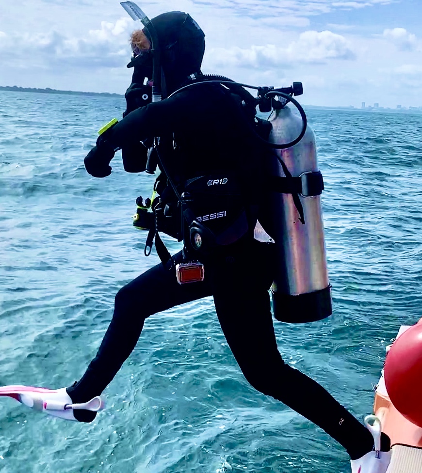 A Scuba Woman performing a Giant Stride
emptynestdiver.com